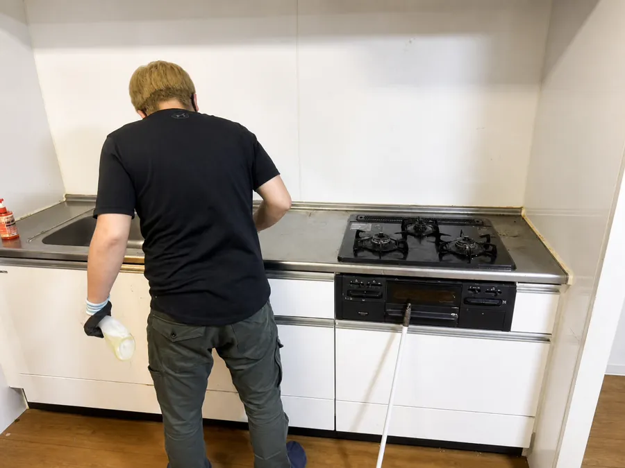 西宮市の家財整理後にスタッフがキッチンを清掃している様子